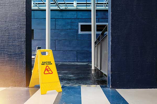 Image of a blue-themed office, with a yellow Caution Wet Floor warning sign